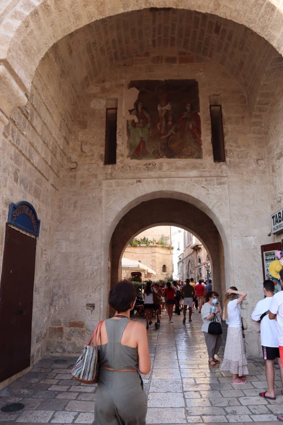 Things to do in Polignano a Mare: walk through Arco Marchesale to enter the historic centre, and admire the painting on the ceiling
